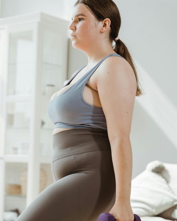 A woman working through a gentle strength exercise with a hand weight